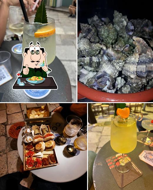 Uno spritz giallo in un bicchiere da vino, con la scorza d'agrume, sul tavolino